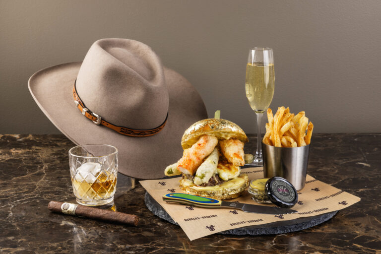 Seafood burger with a glass of champagne and fries. Along with a cowboy hat, cigar and whiskey in Deer Valley
